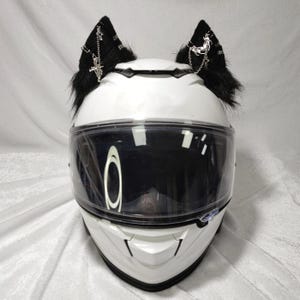May include: White motorcycle helmet with black faux fur cat ears with silver chain and cross accents.