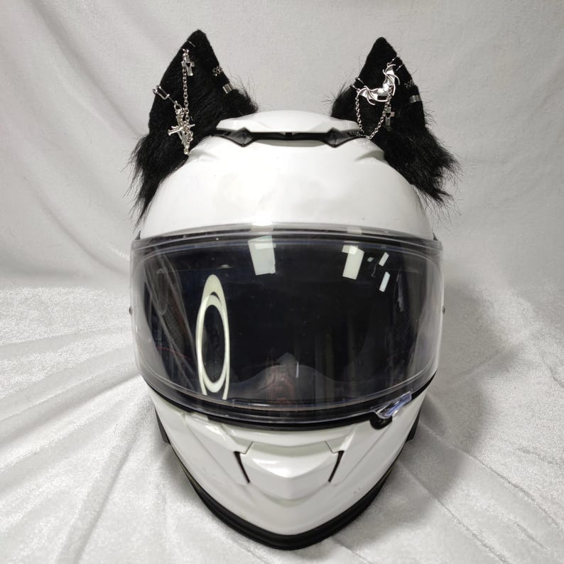 May include: White motorcycle helmet with black faux fur cat ears with silver chain and cross accents.