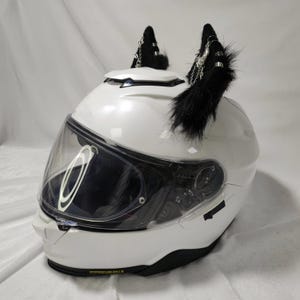 May include: White motorcycle helmet with a clear visor and black faux fur cat ears with silver charms.