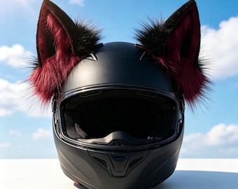 Może przedstawiać: Matowy czarny kask motocyklowy typu full-face z dwiema dużymi, spiczastymi uszami w stylu zwierzęcym przymocowanymi na górze. Uszy mają czarne zewnętrzne krawędzie oraz wyściółkę z ciemnobordowego sztucznego futra, tworząc wyraźny kontrast.