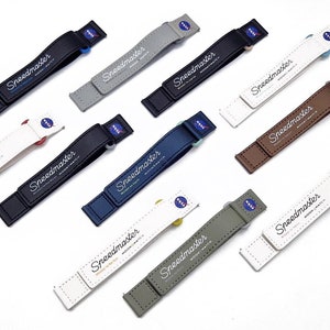 May include: Eight different coloured watch straps with the text "Speedmaster Professional Watch" printed on them. The straps are made of leather, nylon and fabric.