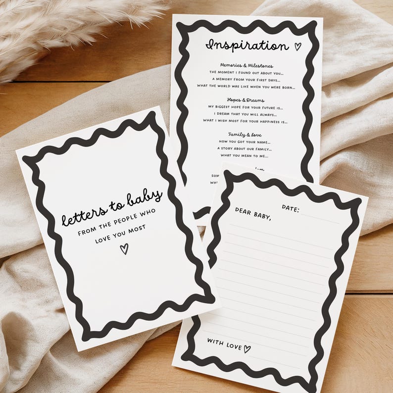 May include: Three white baby memory cards with black wavy borders. One card reads "letters to baby" and "love you most." Another says "Inspiration" with prompts. The third card is a fill-in-the-blank letter, ready to be filled.