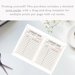 May include: Two cream-colored library cards with black text and lines, featuring the text "LIBRARY CARD" and the number "061825" in red. A pair of scissors and a cup of coffee are also visible.