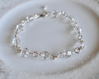 May include: A delicate silver bracelet with clear crystal beads. The bracelet is made with wire wrapped beads and a simple clasp.
