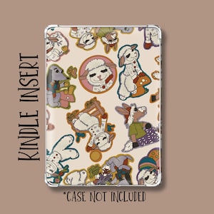 May include: A rectangular Kindle insert featuring a cream background with a repeating pattern of cartoon sheep, dogs, and mushrooms. The text "KINDLE INSERT" is printed vertically on the left, and "*CASE NOT INCLUDED" is at the bottom.