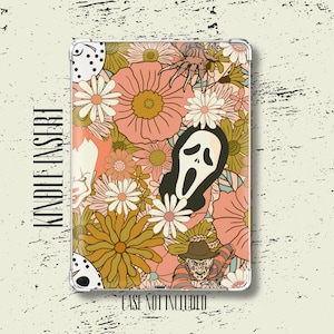 May include: A rectangular Kindle insert featuring a floral pattern in shades of peach, mustard yellow, and white, interspersed with horror movie icons including a hockey mask, a ghost mask, a clawed hand, and a striped sweater figure.