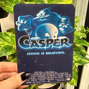 May include: A rectangular Casper movie promotional card with rounded corners featuring the blue-toned title logo, the tagline SEEING IS BELIEVING, and three ghost characters above the Casper character, with production credits printed at the bottom.