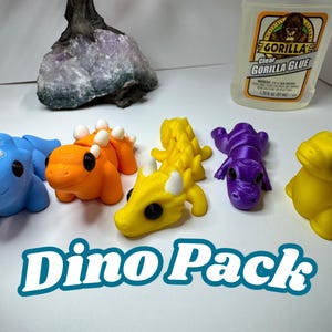 May include: A collection of colorful, 3D-printed dinosaur figurines in blue, orange, yellow, and purple. The image includes a bottle of clear Gorilla Glue and the text "Dino Pack".