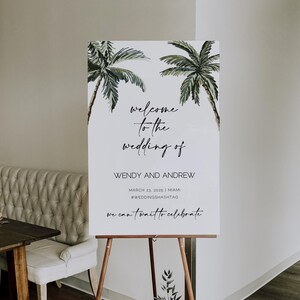 May include: A white welcome sign with a tropical theme featuring two palm trees. The sign reads "welcome to the wedding of Wendy and Andrew" with the date "March 23, 2025" and location "Miami". The hashtag is #WEDDINGSHASHTAG. The sign also says "we can't wait to celebrate" and includes the website "www.citrus-press.com".