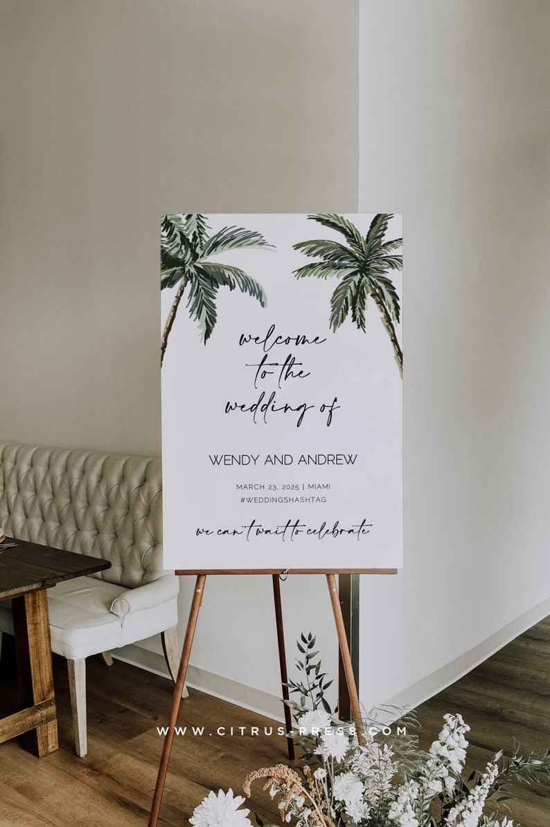 May include: A white welcome sign with a tropical theme featuring two palm trees. The sign reads "welcome to the wedding of Wendy and Andrew" with the date "March 23, 2025" and location "Miami". The hashtag is #WEDDINGSHASHTAG. The sign also says "we can't wait to celebrate" and includes the website "www.citrus-press.com".
