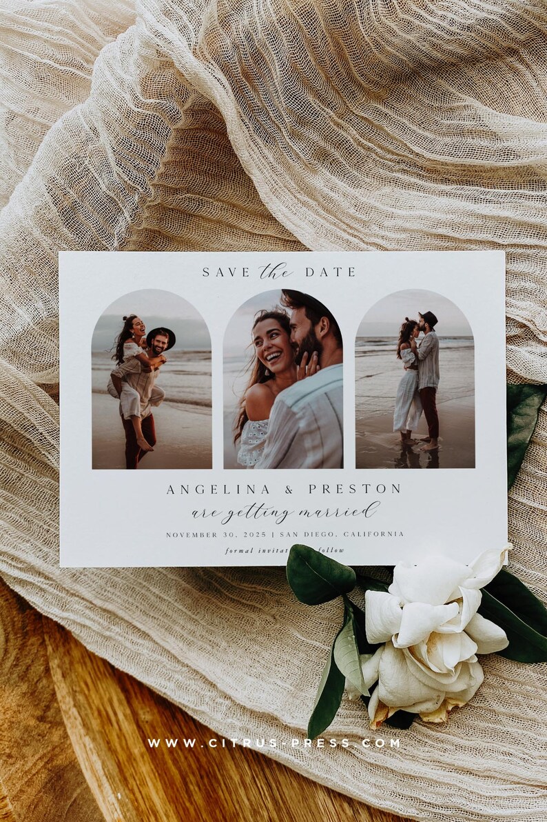 May include: A wedding announcement card featuring three photographs of a couple on a beach. The words "Save the Date" are at the top, with the names "Angelina & Preston" and wedding details below. A white flower and fabric are in the foreground.