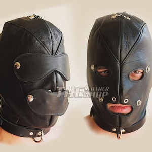 May include: Black leather hood with eye and mouth openings, secured with metal rivets and a neck strap with a D-ring. The hood covers the entire head and face, with a visor over the eyes.