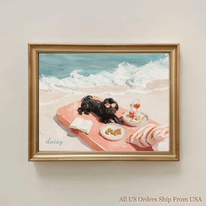 Könnte beinhalten: Gerahmtes Kunstwerk eines schwarzen Hundes mit Sonnenbrille, der auf einer rosa Strandmatte liegt. Ein Buch, Snacks und Getränke befinden sich in der Nähe. Der Hintergrund zeigt eine Strandszene mit Wellen und Sand.
