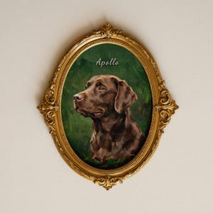 Puede incluir: Un retrato ovalado de un perro Labrador retriever marrón sobre un fondo verde oscuro, con el nombre Apollo en letras blancas sobre el perro. La pintura está enmarcada en un marco ovalado ornamentado de color dorado con detalles.
