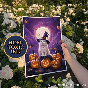 Puede incluir: Una impresión de Halloween con un gato blanco con un sombrero de bruja, rodeado de calabazas y una luna llena. El texto "NON-TOXIC INK" está incluido en un logotipo circular.