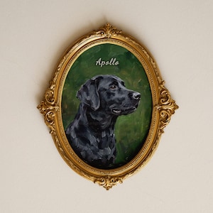 Puede incluir: Un marco dorado ovalado y ornamentado que contiene un retrato pintado de un perro Labrador negro de perfil. El perro está sobre un fondo verde oscuro texturizado. El nombre Apollo está escrito en letra cursiva blanca sobre la cabeza.