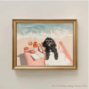 May include: A framed print showing a black dog wearing sunglasses, relaxing on a beach towel with a bottle of wine, two glasses, and a book. The word "cinnamon" is written in the upper left corner. The background shows a beach and ocean.