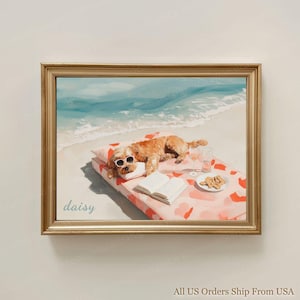 May include: A framed print shows a dog wearing sunglasses, lounging on a beach towel with a book and snacks. The beach scene includes a light blue ocean and white sand. The dog's name, "daisy", is written in cursive. The print is in a gold frame.