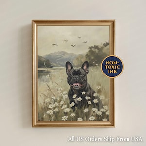 May include: A framed print featuring a black French Bulldog in a field of white daisies. The artwork has a vintage style with a landscape background of mountains, a lake, and birds in the sky. The frame is gold-colored.