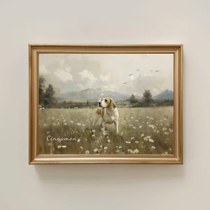 May include: A framed painting of a beagle dog standing in a field of white flowers. The dog is brown and white, with a long tail. The painting has a gold frame and the word "Cinnamon" is written in the bottom left corner.