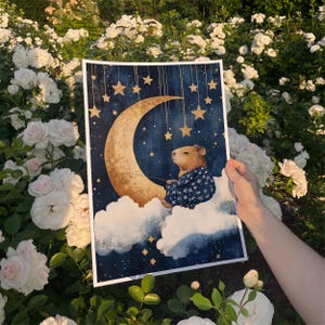 Impresión en lienzo de un carpincho sentado en una luna creciente. Bonita decoración infantil para bebé recién nacido. Obra de arte caprichosa de un carpincho.