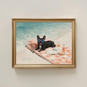 May include: A framed painting of a black French Bulldog wearing blue sunglasses, lying on a peach-coloured patterned beach towel on the sand. Beside the dog is an open book, a glass of wine, and a bottle. The name Apollo is written in white.