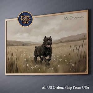 Puede incluir: Una impresión enmarcada que representa a un perro negro corriendo por un campo de flores silvestres. La obra de arte tiene un tono sepia, con el texto "Ms. Cinnamon" y "Non-Toxic Ink" visibles. La impresión está en un marco de madera.