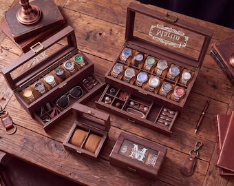 May include: A collection of dark brown wooden watch and jewelry storage boxes with glass lids. The boxes feature internal compartments, watch pillows, and drawers for accessories. Some lids are engraved with the names Martin or initials.