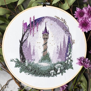 May include: An embroidered hoop art piece featuring a fairytale tower scene. The artwork showcases a tall, brown tower with a purple roof, surrounded by purple trees and green foliage. The embroidery is set against a white background.