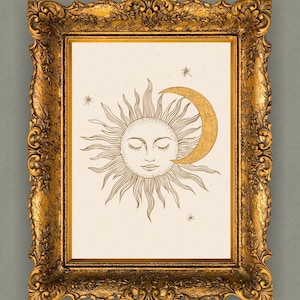 Puede incluir: Una impresión enmarcada con un diseño celestial de un sol y una luna creciente. El sol tiene los ojos cerrados y líneas radiantes. La luna es dorada y el marco es dorado ornamentado. El fondo es blanquecino con pequeños puntos.