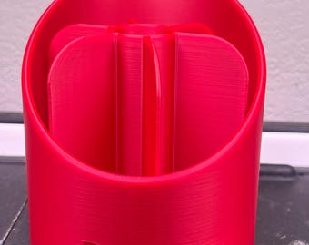 May include: A bright red plastic brush holder with the word "Brushes" printed on the front.