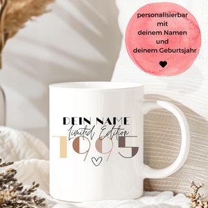 May include: White ceramic mug with black text that reads "Dein Name Limited Edition 1995" with a small heart symbol. The numbers 1, 9, 9, and 5 are in different colors of brown and beige.