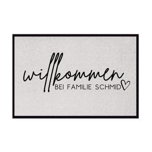 Peut inclure: Un paillasson gris avec du texte noir qui dit "Willkommen bei Familie Schmid" avec un petit symbole de c&oelig;ur.