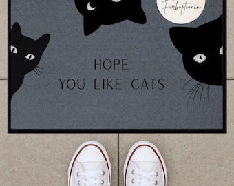 Könnte beinhalten: Eine graue Fußmatte mit schwarzen Katzen-Silhouetten und dem Text "HOPE YOU LIKE CATS".