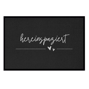 May include: Black doormat with white text that says "herein spaziert" with two small white hearts.