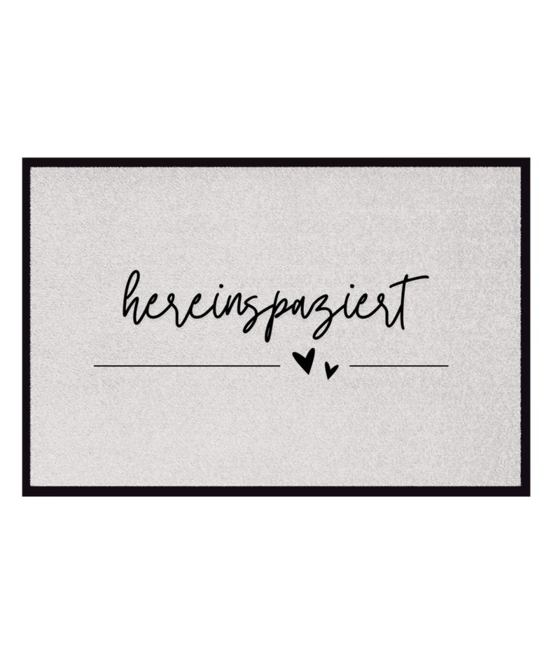 May include: A gray doormat with black text that says "herein spaziert" with two small black hearts underneath the text.