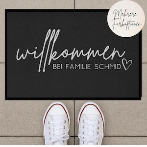 Peut inclure: Paillasson d'accueil noir avec du texte blanc qui dit "Willkommen bei Familie Schmid" avec un symbole de c&oelig;ur.