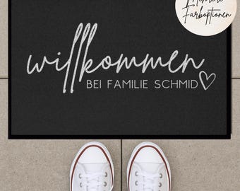 Könnte beinhalten: Schwarze Willkommensmatte mit weißem Text, der "Willkommen bei Familie Schmid" mit einem Herzsymbol sagt.