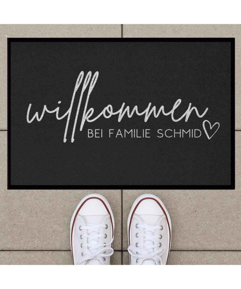 Peut inclure: Paillasson d'accueil noir avec du texte blanc qui dit "Willkommen bei Familie Schmid" avec un symbole de c&oelig;ur.