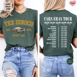 a green t-shirt with a graphic design of a classic car from the Disney Cars movie franchise. The t-shirt has text and numbers printed on it, indicating the years the cars were established.