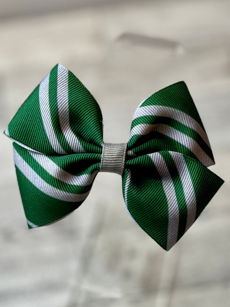 May include: Green and white striped hair bow with a silver center.