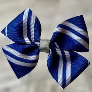 May include: A blue and white striped hair bow with a silver center.