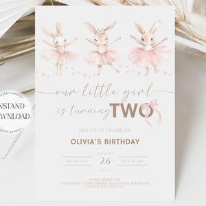 Op de afbeelding: Een lichtbeige verjaardagsuitnodiging met drie aquarelkonijntjes in roze tutu's. De tekst luidt "our little girl is turning TWO" en bevat details voor Olivia's verjaardag, 26 januari 2026.
