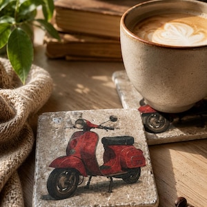 Könnte beinhalten: Quadratische Untersetzer aus Stein mit einem roten Vintage-Roller-Design. Die Untersetzer sind beige mit einer strukturierten Oberfläche. Eine Tasse Kaffee steht auf einem Untersetzer, Kaffeebohnen sind verstreut. Das Bild hat eine warme, einladende Ästhetik.