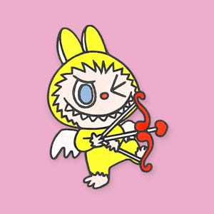 May include: A cartoon illustration of a yellow bunny-like creature with a mischievous grin, holding a red bow and arrow. The character has white wings and is set against a pink background. The design is outlined in black.