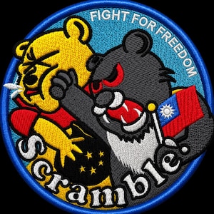 May include: Embroidered patch with a blue border featuring two cartoon bears in a fight. One bear is yellow, the other is grey, holding a flag with a red background and a white sun. Text includes "FIGHT FOR FREEDOM" and "Scramble!"
