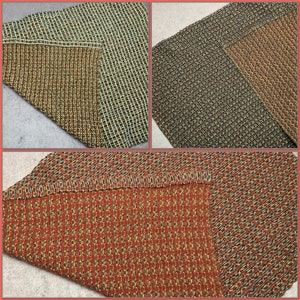 May include: Three different woven rugs with a geometric pattern. The rugs are in shades of brown, green, and orange.