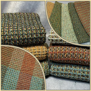 May include: A stack of woven kitchen towels in various colors, including green, blue, brown, and yellow. The towels are made of a soft, textured fabric and have a subtle pattern.