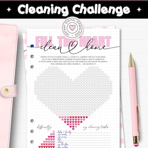 May include: A printable cleaning challenge journal page with a heart-shaped design made of hearts. The page includes the text "Cleaning Challenge" and "Fill the Heart, Clean Home". A pink pen rests on the page.