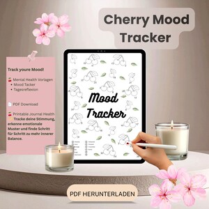 Könnte beinhalten: Ein digitales Tablet zeigt eine Stimmungs-Tracker-Seite mit nummerierten Kirschillustrationen zur täglichen Protokollierung. Der Bildschirm zeigt den Text Mood Tracker und eine Liste von Emotionen. Zwei brennende Kerzen in Gläsern flankieren das Tablet, verziert mit rosa Kirschblüten.